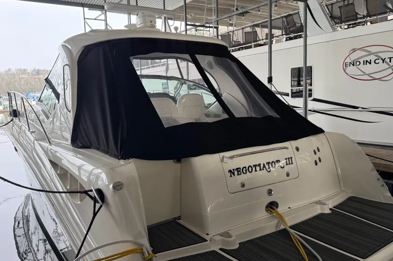 Slide: The Image of 2007 Sea Ray Sundancer 400 yacht docked, rear view with black canopy and "Negotiator III" name. - 3