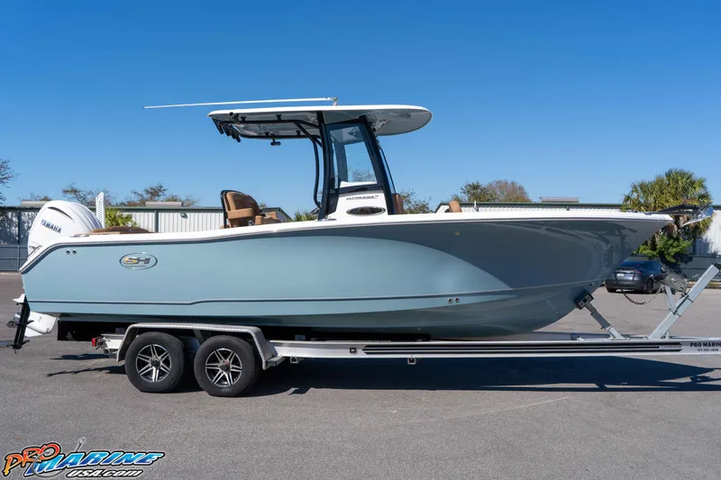 Slide: The Image of 2023 Sea Hunt Ultra 255 SE boat on trailer, side view, clear sky background. - 11