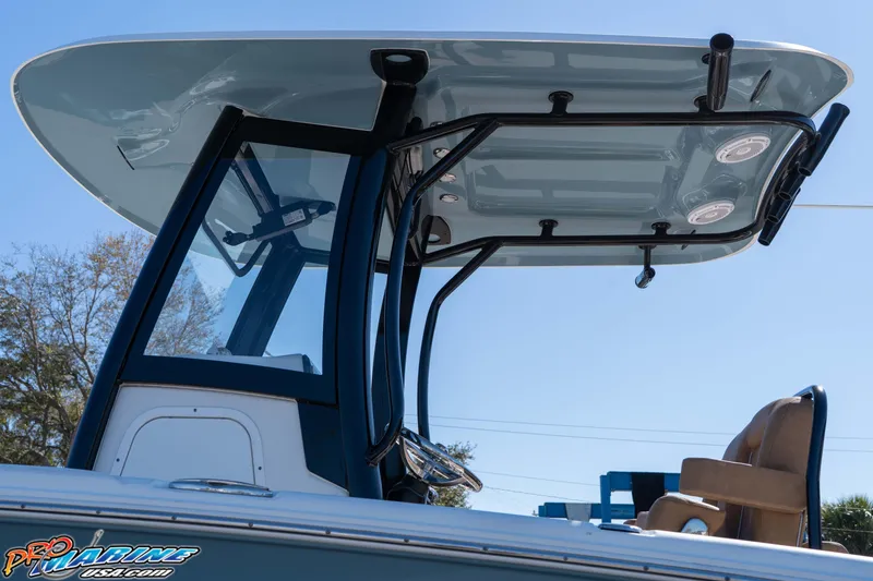 Slide: The Image of 2023 Sea Hunt Ultra 255 SE boat with T-top and seating, under clear blue sky. - 14