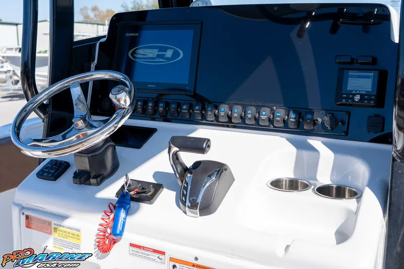 Slide: The Image of 2023 Sea Hunt Ultra 255 SE boat dashboard with steering wheel and control panel. - 25
