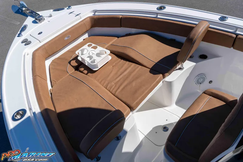 Slide: The Image of 2023 Sea Hunt Ultra 255 SE boat interior with brown cushioned seating and cup holders. - 29
