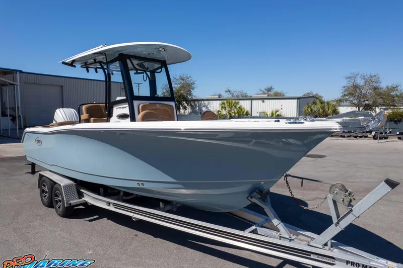 Slide: The Image of 2023 Sea Hunt Ultra 255 SE boat on trailer, parked outdoors under clear blue sky. - 31