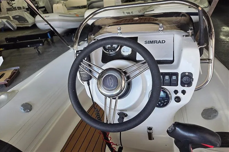 Slide: The Image of 2021 Walker Bay Generation 360 boat dashboard with steering wheel and Simrad display. - 6