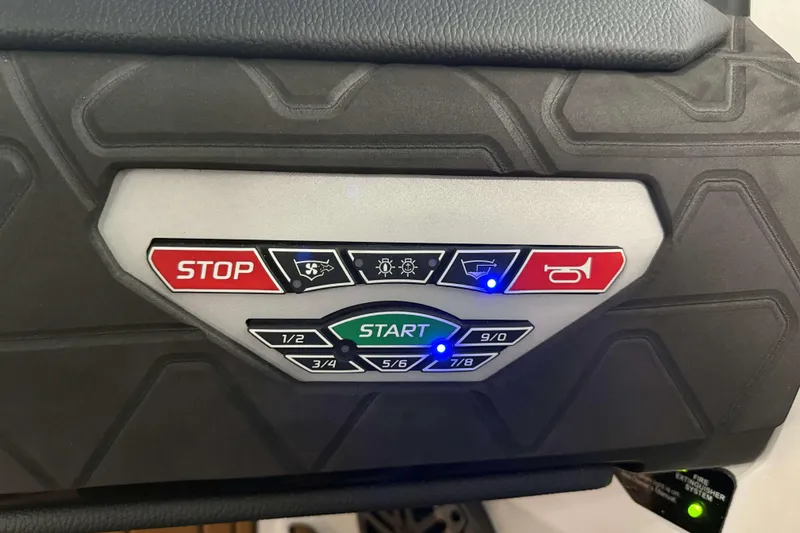 Slide: The Image of Control panel of 2026 Nautique Super Air Nautique GS22 with start and stop buttons. - 21