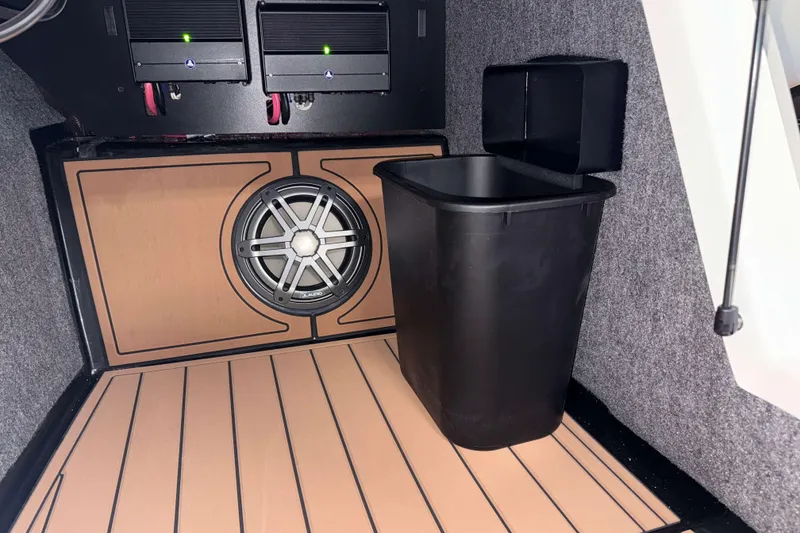 Slide: The Image of 2026 Nautique Super Air Nautique GS22 interior with subwoofer and storage bin. - 25