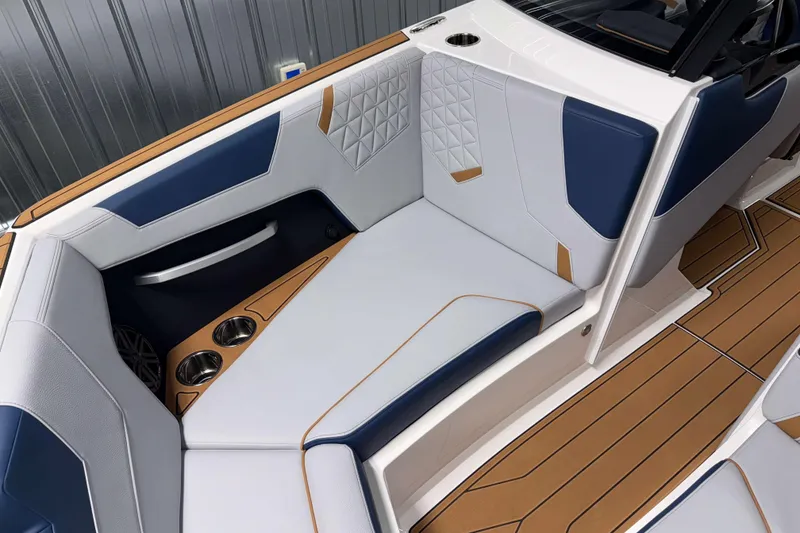 Slide: The Image of 2026 Nautique Super Air Nautique GS22 interior with blue and white seating, cup holders, and teak flooring. - 31