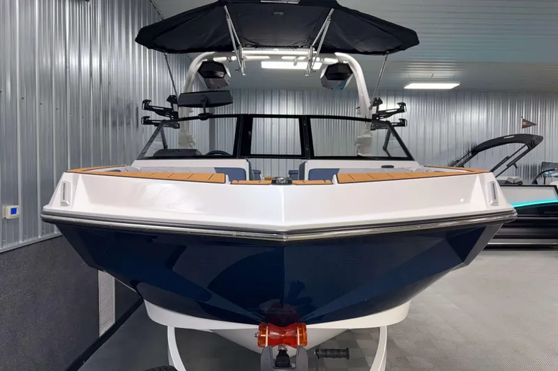 Slide: The Image of 2026 Nautique Super Air Nautique GS22 boat in showroom, front view, sleek design. - 33