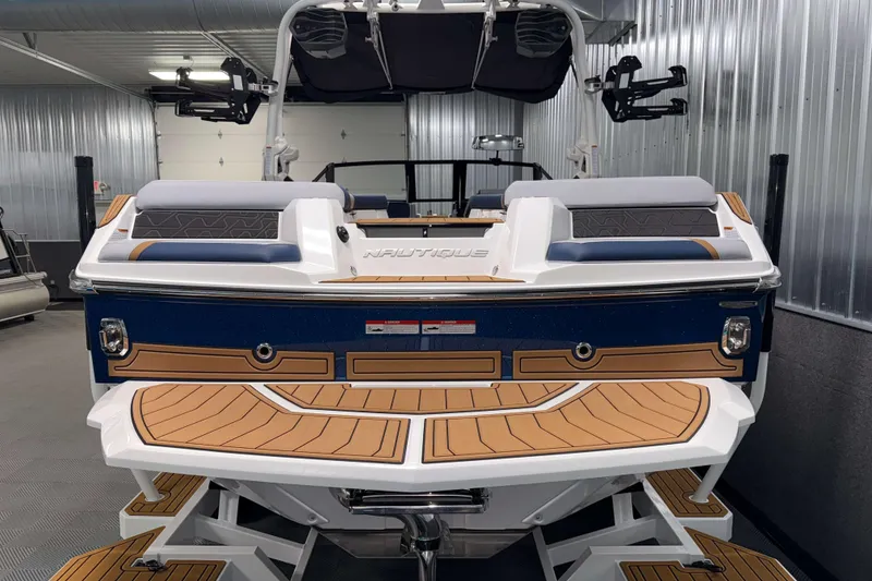 Slide: The Image of 2026 Nautique Super Air Nautique GS22 boat in a showroom, rear view. - 36
