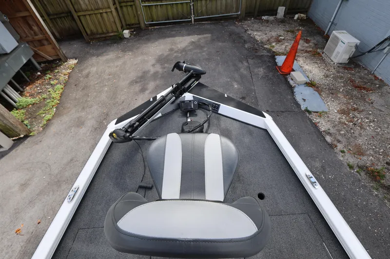 Slide: The Image of 2023 Vexus AVX189 boat interior with seat and trolling motor in driveway. - 15