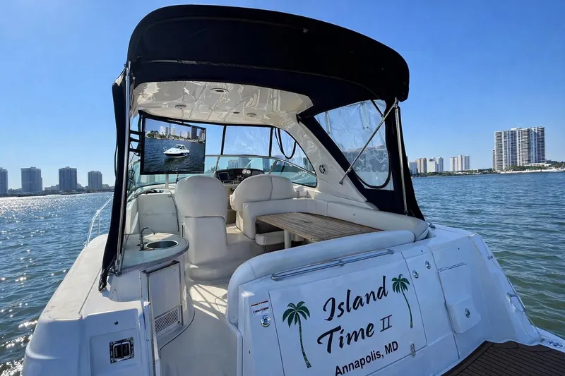 Slide: The Image of 2005 Four Winns 378 Vista yacht on water, featuring spacious seating and city skyline backdrop. - 11