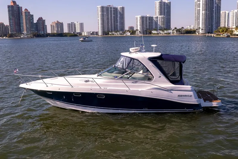 Slide: The Image of 2005 Four Winns 378 Vista yacht cruising on water with city skyline in background. - 2