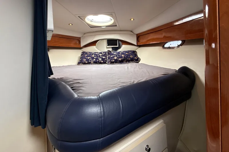 Slide: The Image of 2005 Four Winns 378 Vista cabin interior with bed, wood accents, and porthole. - 20