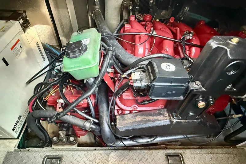 Slide: The Image of Engine compartment of a 2005 Four Winns 378 Vista boat, featuring red engine components. - 23