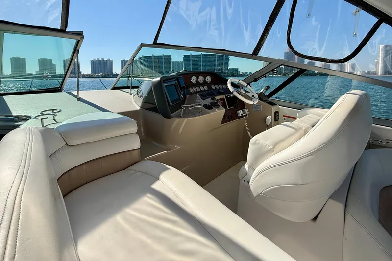 Slide: The Image of 2005 Four Winns 378 Vista yacht cockpit with luxurious seating and modern controls, overlooking city skyline. - 8