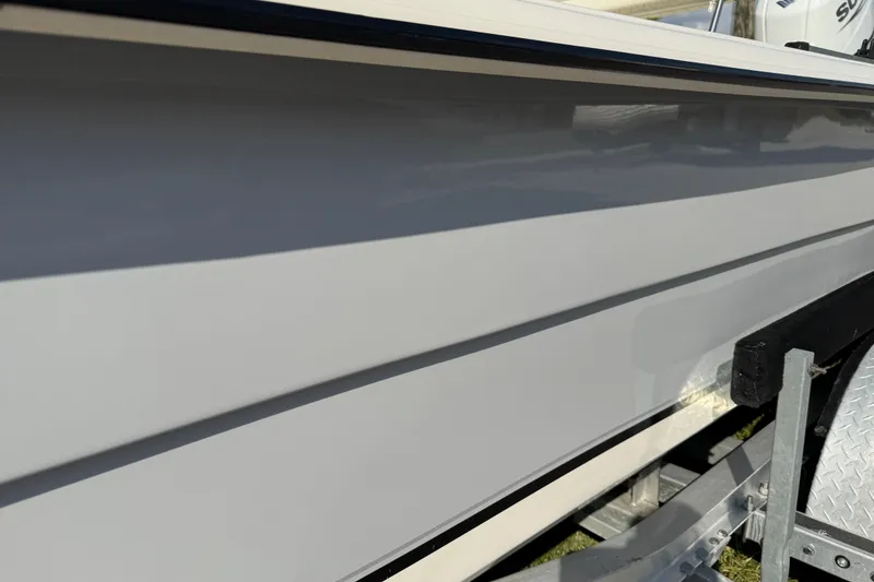 Slide: The Image of 2023 Carolina Skiff 21 SWS boat on trailer, parked on a sunny street. - 10