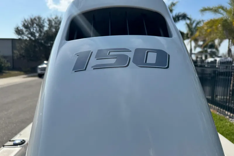 Slide: The Image of 2023 Carolina Skiff 21 SWS with Suzuki four-stroke engine, palm trees in background. - 15