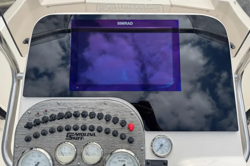 Slide: The Image of Control panel of a 2023 Carolina Skiff 21 SWS boat with gauges and switches. - 24