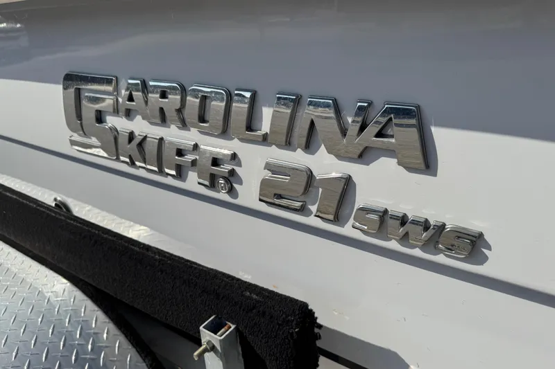 Slide: The Image of 2023 Carolina Skiff 21 SWS boat on trailer, parked near palm trees. - 3