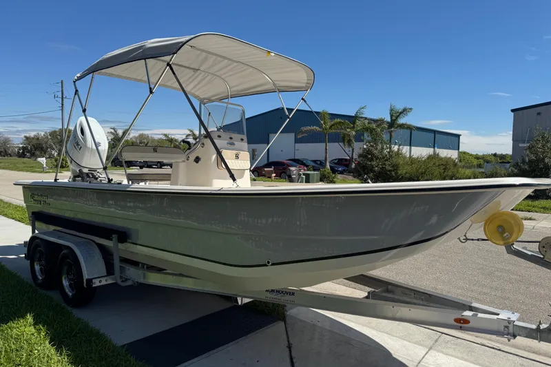Slide: The Image of 2023 Carolina Skiff 21 SWS boat on trailer with canopy, parked outdoors. - 82
