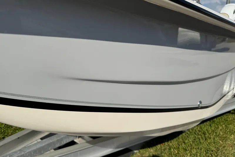 Slide: The Image of 2023 Carolina Skiff 21 SWS boat on trailer, parked outdoors under a partly cloudy sky. - 9