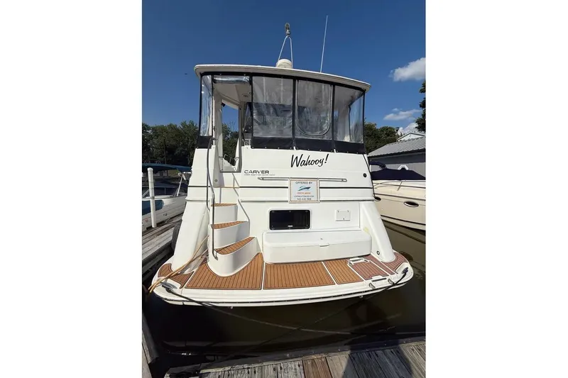 The Image of 2001 Carver 396 Aft Cabin Motor Yacht docked, rear view with wooden deck. - 0