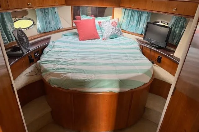 Slide: The Image of Cozy bedroom in 2001 Carver 396 Aft Cabin Motor Yacht with striped bedding and TV. - 3