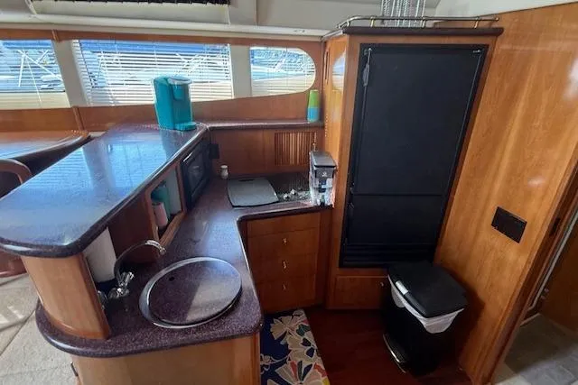 Slide: The Image of Interior of 2001 Carver 396 Aft Cabin Motor Yacht with kitchenette and wood finish. - 5