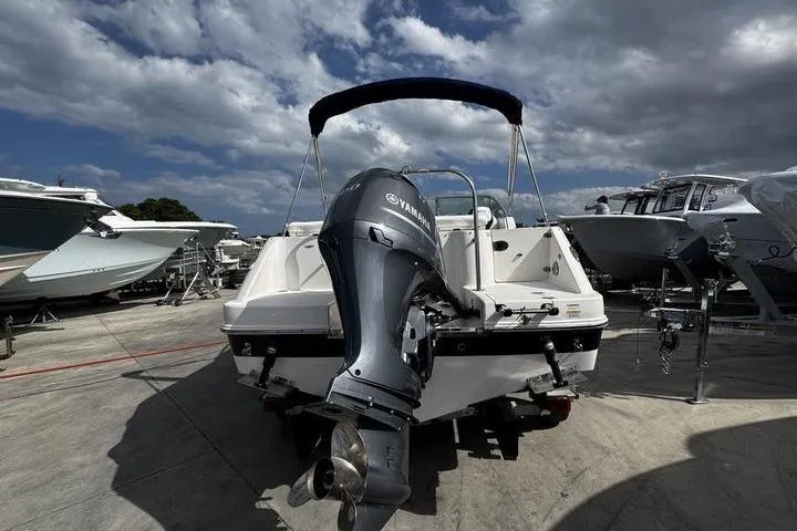 Slide: The Image of 2021 Robalo R227 Dual Console boat with Yamaha outboard motor, docked under cloudy sky. - 3