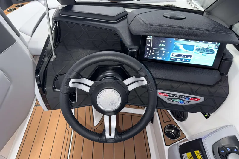 Slide: The Image of 2026 Nautique Super Air Nautique GS22 dashboard with touchscreen and steering wheel. - 18