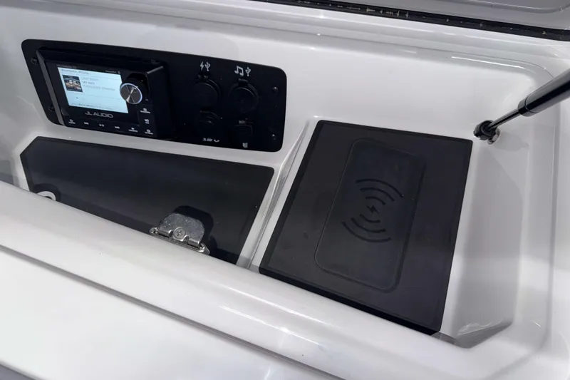 Slide: The Image of 2026 Nautique Super Air Nautique GS22 dashboard with JL Audio system and wireless charging pad. - 26