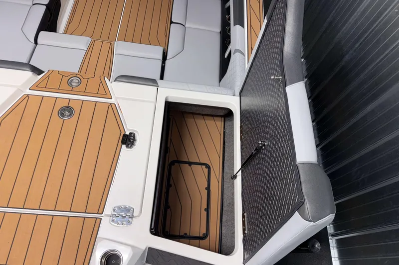 Slide: The Image of 2026 Nautique Super Air Nautique GS22 interior with open storage compartment and cushioned seating. - 43