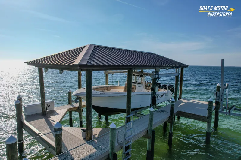Slide: The Image of 2018 Key West Billistic 351 Center Console boat docked under a covered pier. - 11