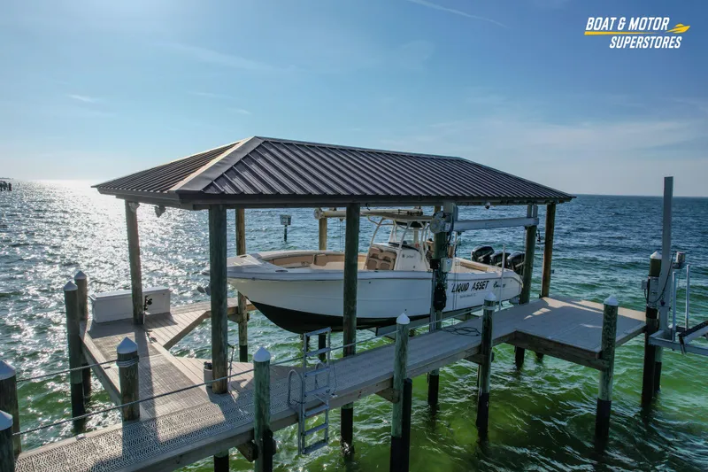 Slide: The Image of 2018 Key West Billistic 351 Center Console boat docked under a covered pier. - 12