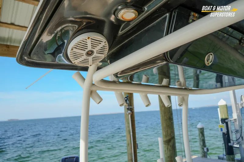 Slide: The Image of 2018 Key West Billistic 351 Center Console boat with rod holders and speaker, docked by the sea. - 124