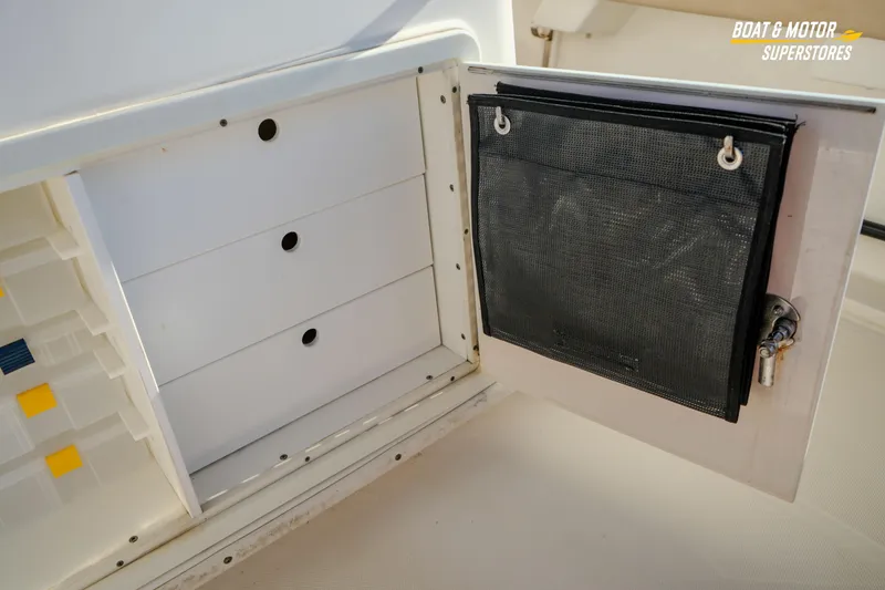 Slide: The Image of 2018 Key West Billistic 351 Center Console storage compartment with open door and organizer. - 129