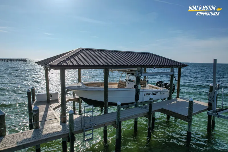 Slide: The Image of 2018 Key West Billistic 351 Center Console boat docked under a covered pier. - 13