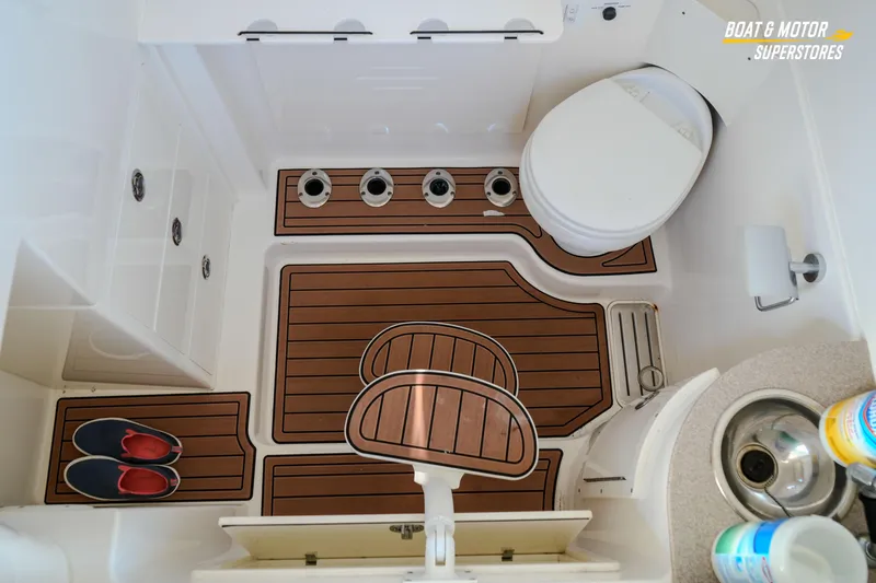 Slide: The Image of 2018 Key West Billistic 351 Center Console boat interior with toilet and wooden flooring. - 142