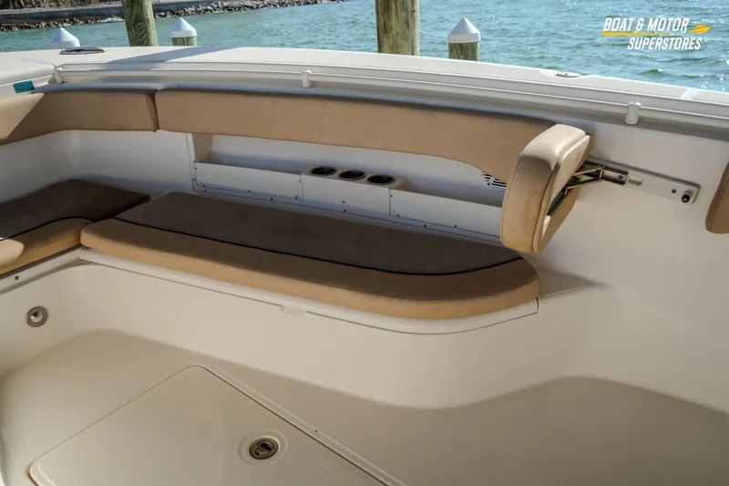Slide: The Image of 2018 Key West Billistic 351 Center Console interior seating with beige cushions, dockside view. - 146