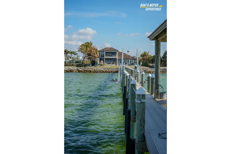 Slide: The Image of Dock view with a Key West Billistic 351 Center Console, 2018 model, in a serene waterfront setting. - 161