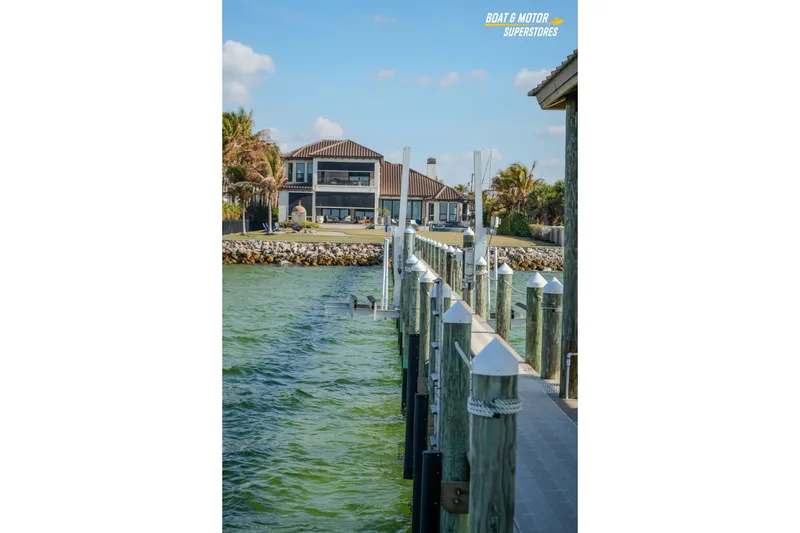 Slide: The Image of Dockside view with a waterfront house, featuring a 2018 Key West Billistic 351 Center Console. - 162