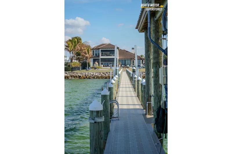 Slide: The Image of Dock leading to waterfront property, clear skies, and calm waters. Key West Billistic 351 Center Console, 2018. - 164