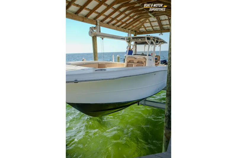 Slide: The Image of 2018 Key West Billistic 351 Center Console boat docked under a wooden canopy. - 171