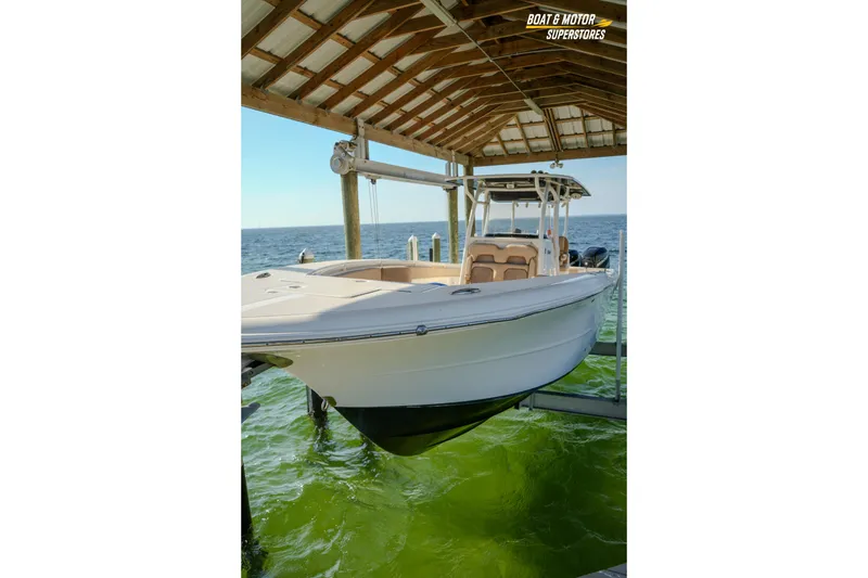 Slide: The Image of 2018 Key West Billistic 351 Center Console boat docked under a wooden shelter. - 172