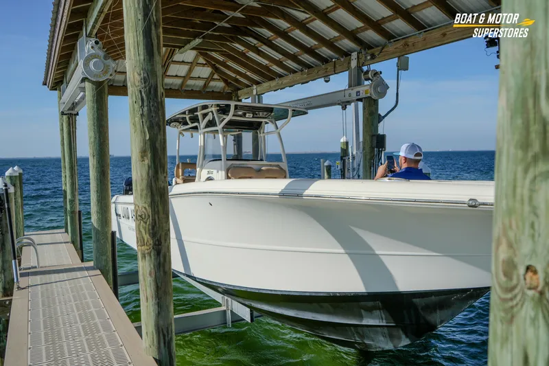 Slide: The Image of 2018 Key West Billistic 351 Center Console boat on lift by ocean dock. - 176