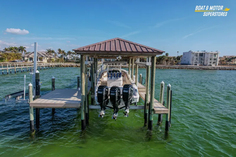 Slide: The Image of 2018 Key West Billistic 351 Center Console docked at marina with triple engines. - 18