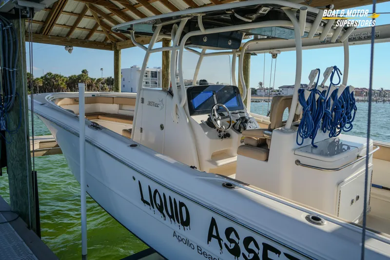 Slide: The Image of 2018 Key West Billistic 351 Center Console boat docked under a wooden canopy. - 184