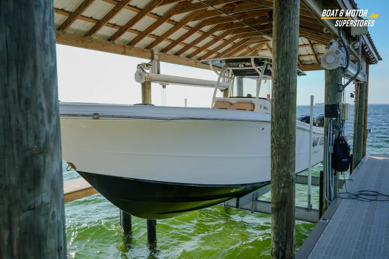 Slide: The Image of 2018 Key West Billistic 351 Center Console boat on lift at dockside. - 186