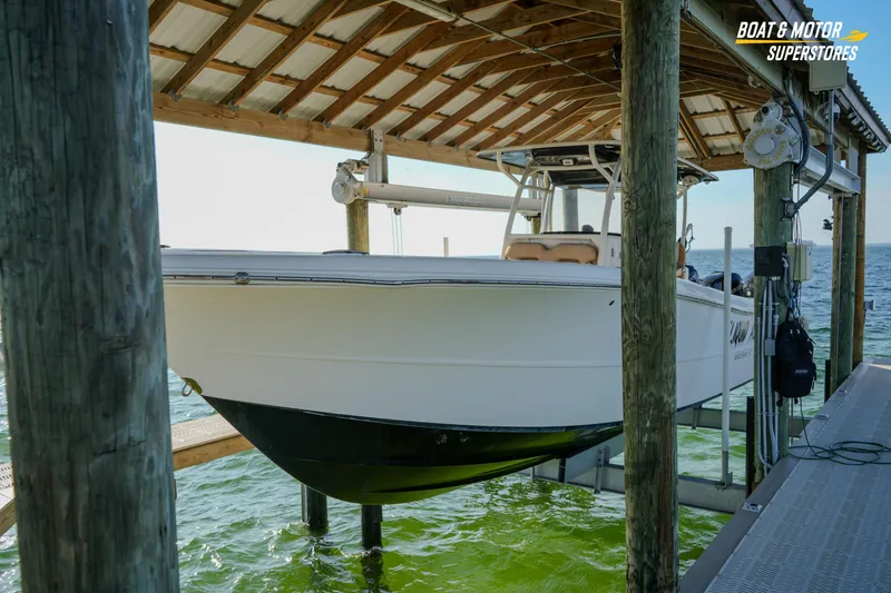 Slide: The Image of 2018 Key West Billistic 351 Center Console boat docked under a wooden shelter. - 187