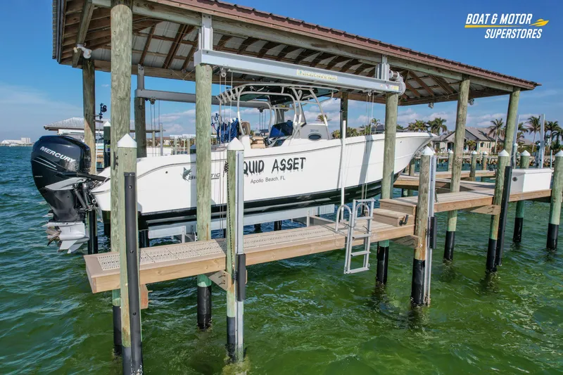 Slide: The Image of 2018 Key West Billistic 351 Center Console boat docked on lift in marina. - 2