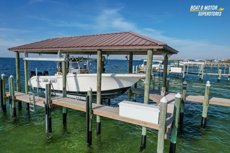 Slide: The Image of 2018 Key West Billistic 351 Center Console boat docked under a covered pier. - 31